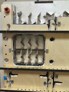 Окошко в оснастке для удаления облоя в нижней части формы с разделителями облоя